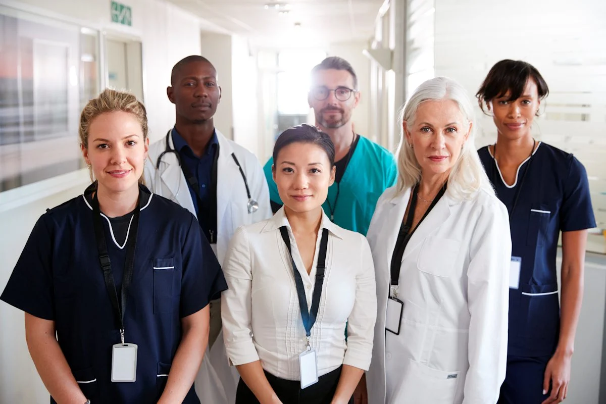 Group of healthcare professionals standing together in a hospital corridor.