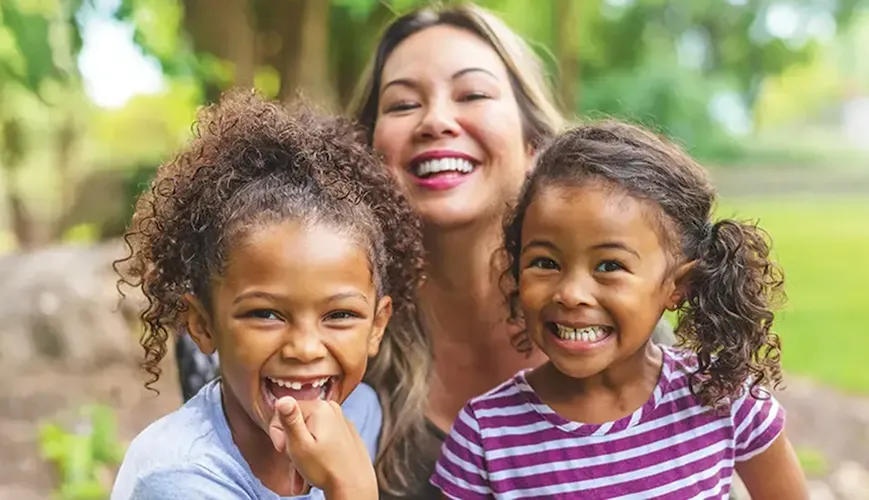 Female adult and two girls smiling Female adult and two girls smiling