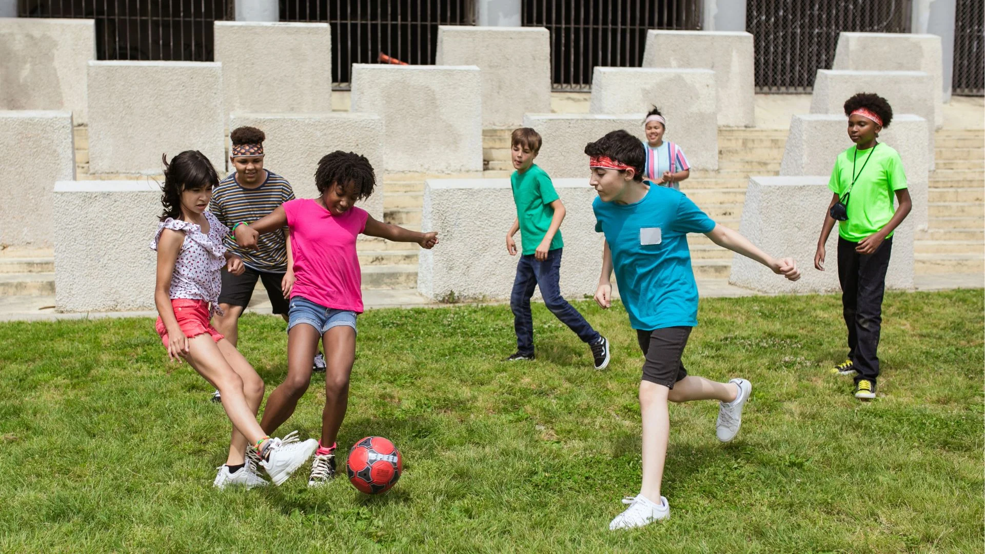Spauling-pioneer-in-child-welfare Multiracial children playing with soccer ball.